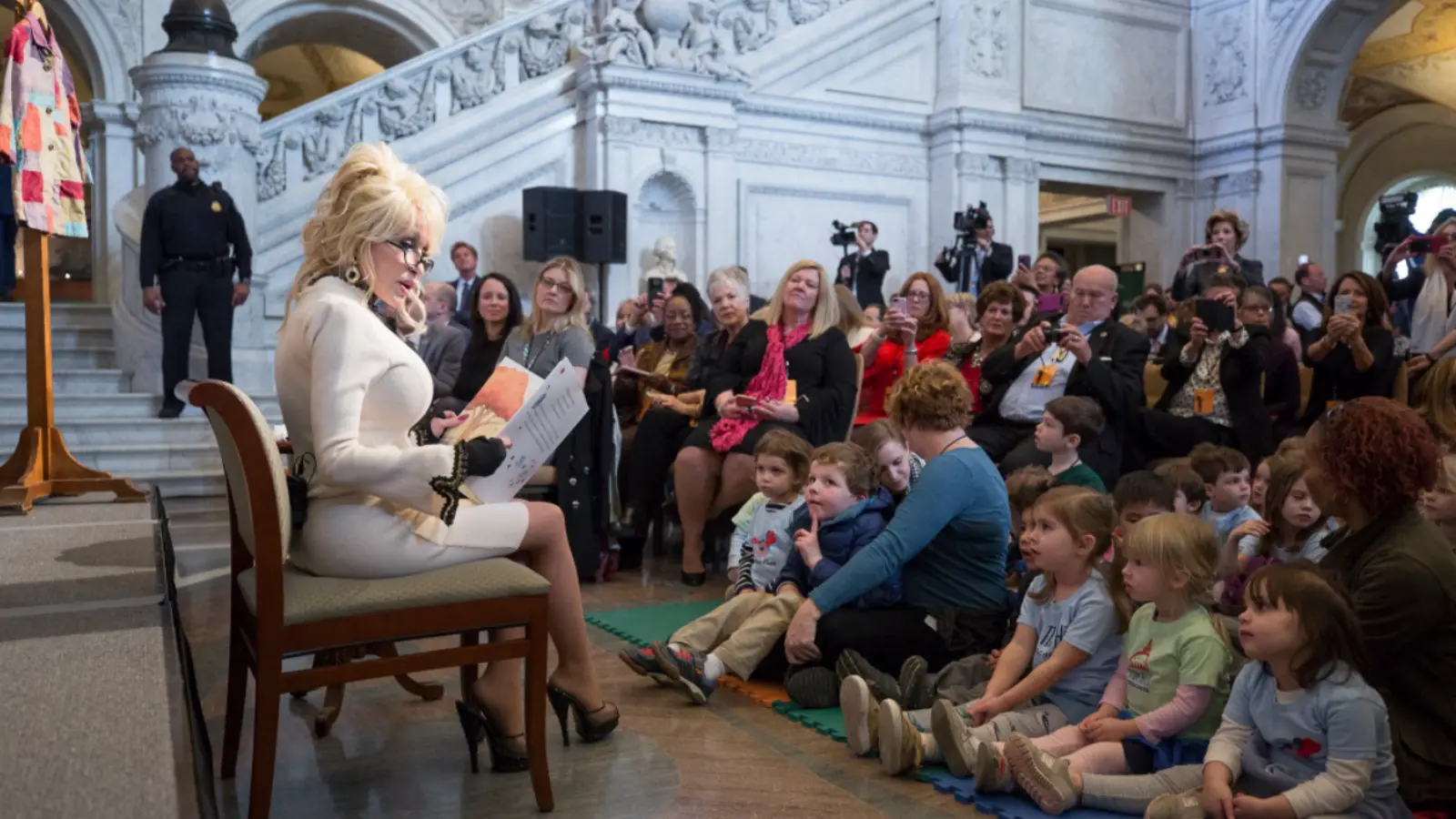 Dolly Parton lee un libro a un grupo de niños en el Gran Salón de la Biblioteca del Congreso en 2018.