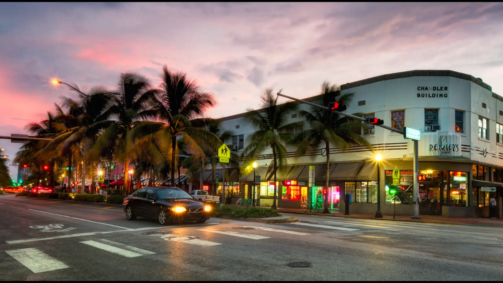 Esquina de South Beach con palmeras, luces y edificios art déco al anochecer