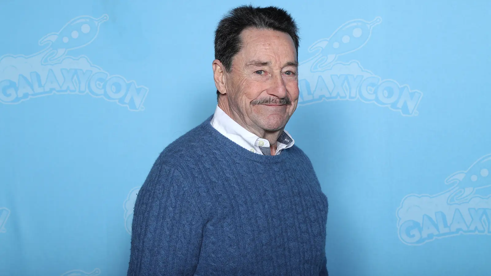 Peter Cullen sonríe ante el fondo de GalaxyCon Richmond en 2020.