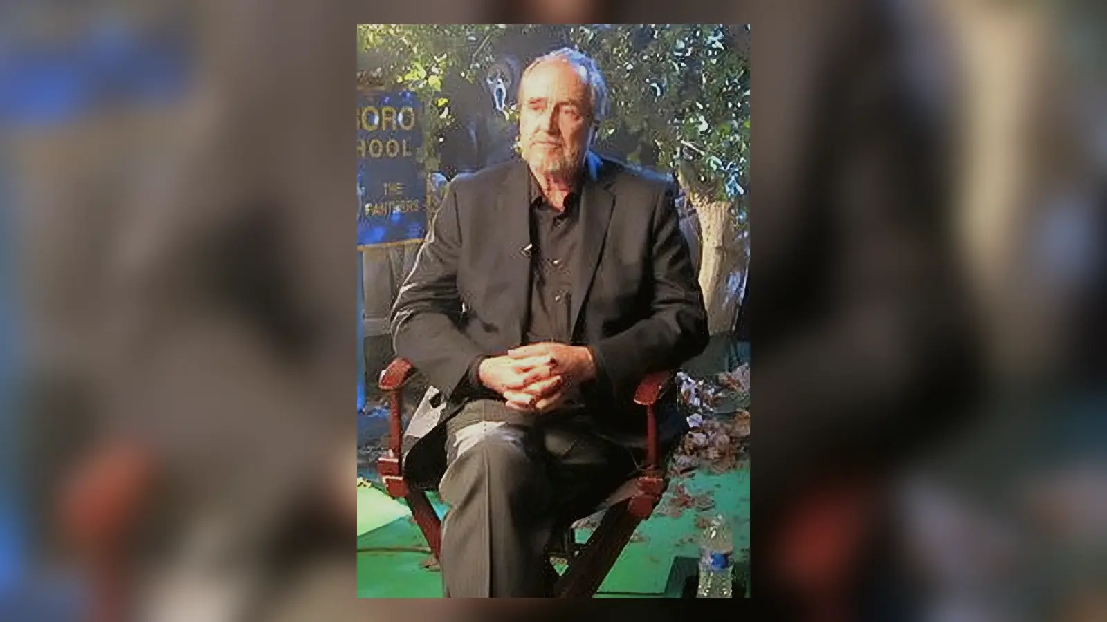 Wes Craven sentado frente a las cámaras durante el documental Scream: The Inside Story en 2010