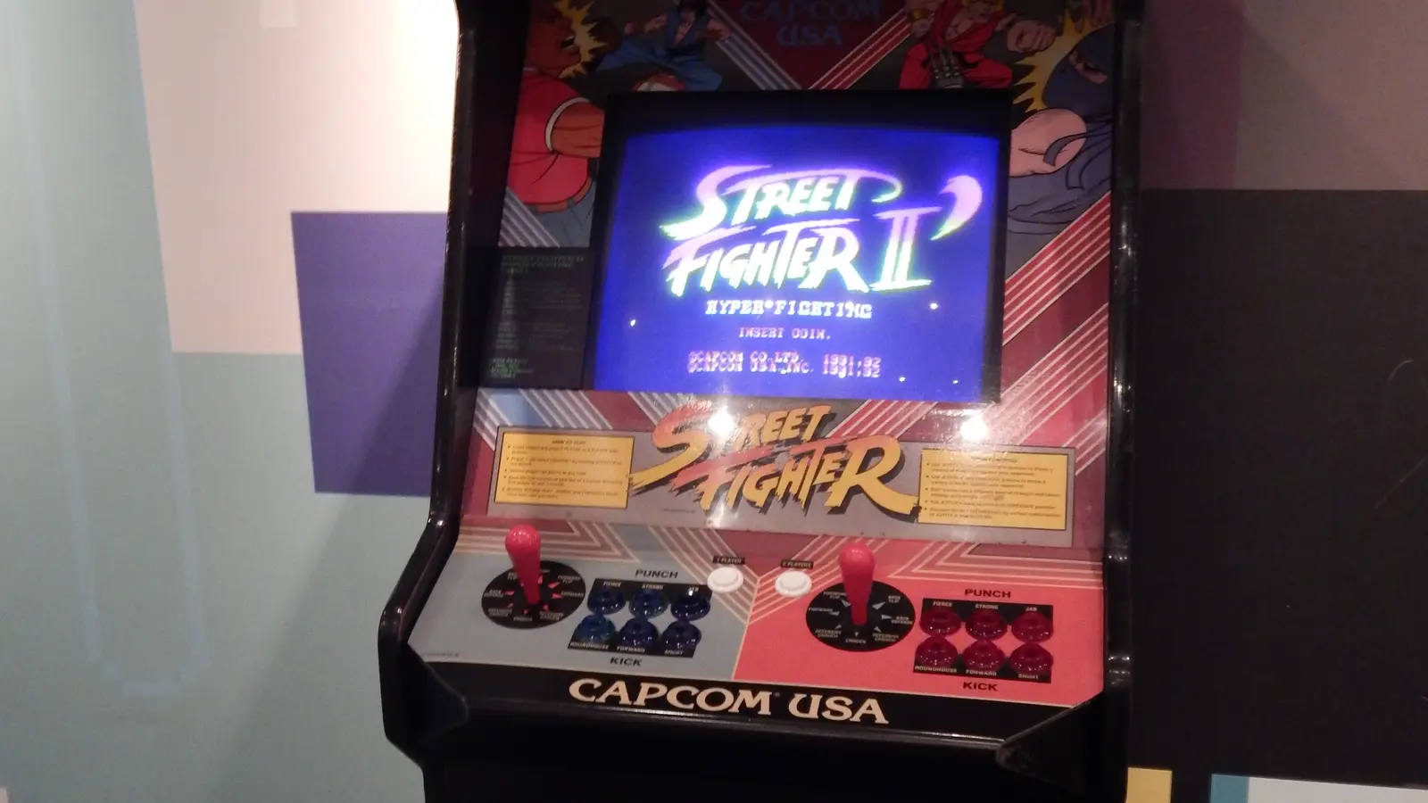 Máquina arcade de Street Fighter II encendida en una exposición de videojuegos.