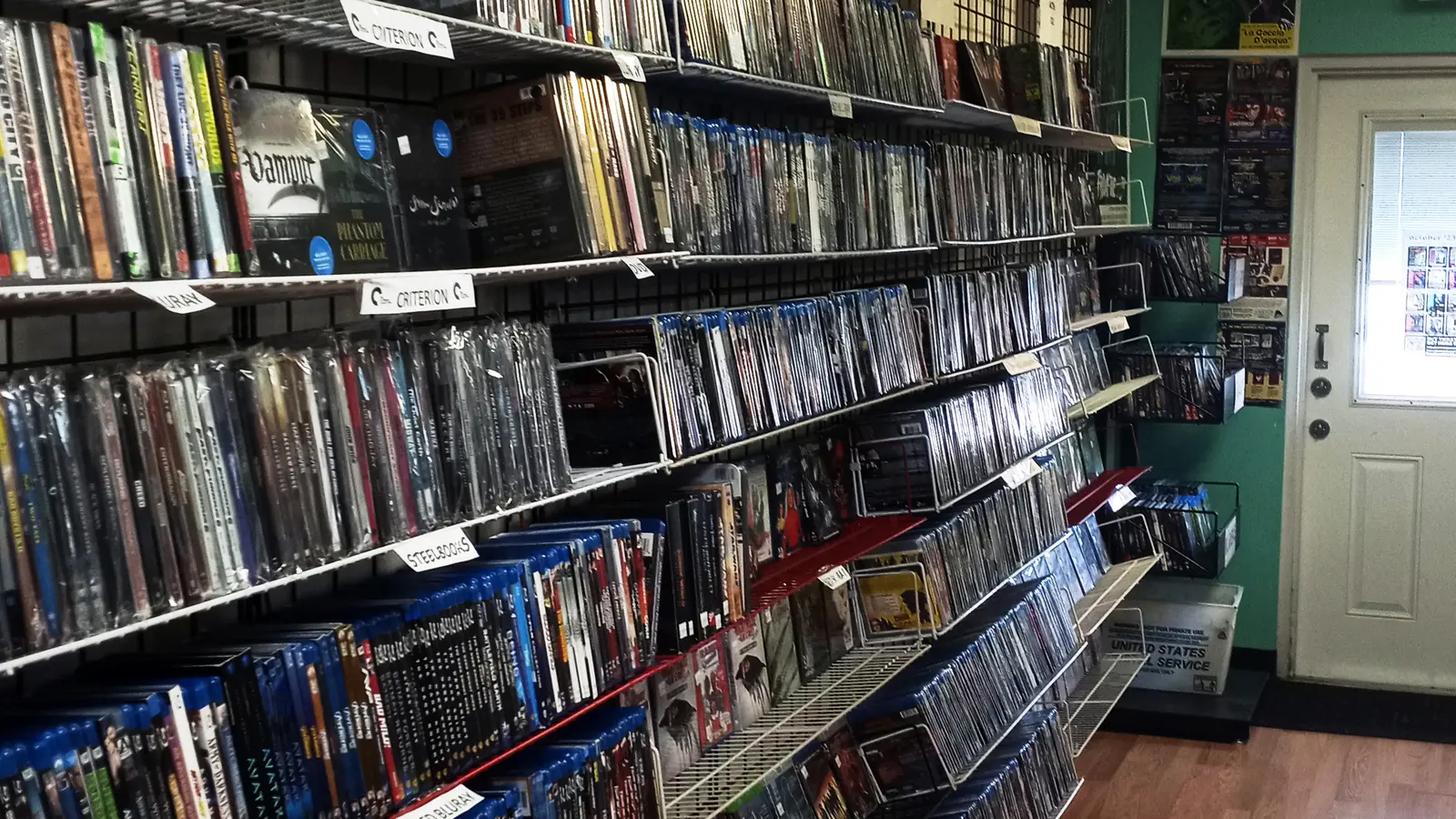 Interior contemporáneo de un videoclub independiente con estanterías llenas de películas.